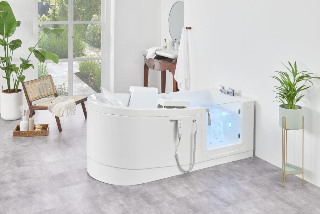The Venezia (Easy Riser) walk-in bath features a sleek, speedboat-inspired design and an electronically controlled seat filled with water to almost the very top. Situated as a T shape against the wall
